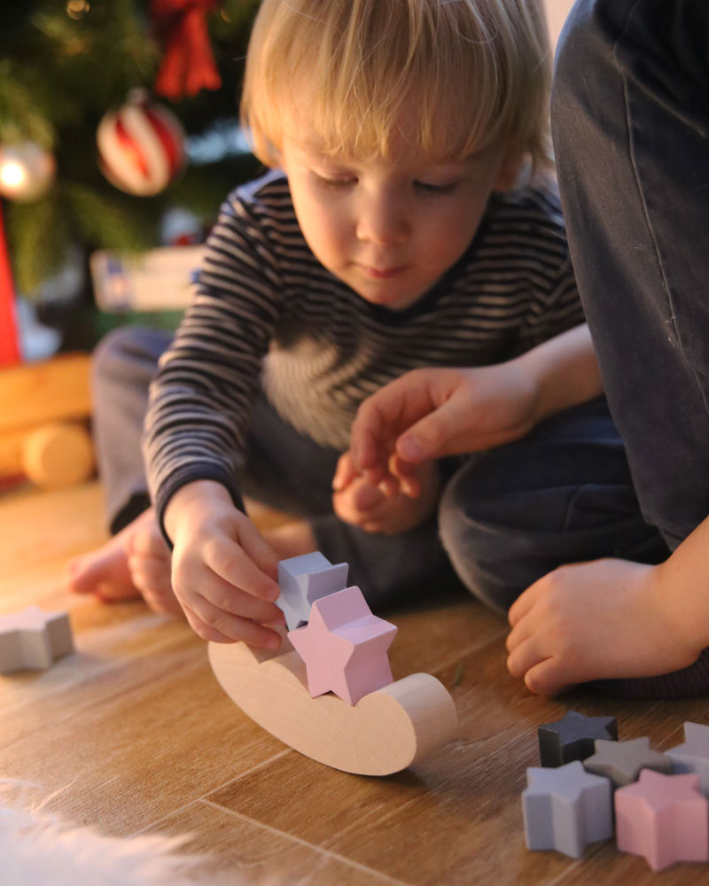 Enfant avec le jouet en bois du ciel étoilé de Selecta