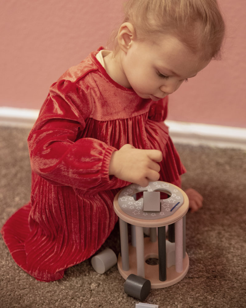 Enfant avec des jouets en bois en forme de rouleau etoile de Selecta