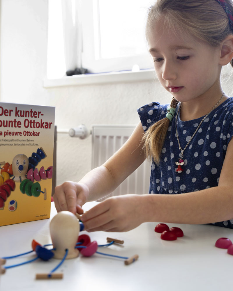 Un enfant avec des jouets en bois Ottokar colorés par Selecta